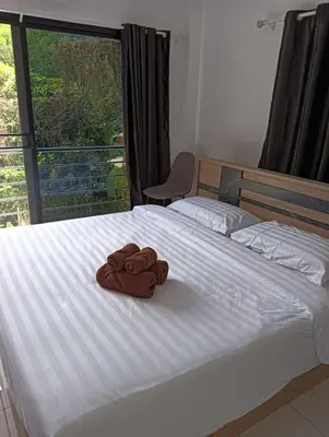 a pair of brown towels sitting on a bed at Kamala House in Kamala Beach