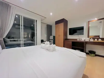 a bedroom with a large white bed and a bathroom at One Houses in Patong Beach