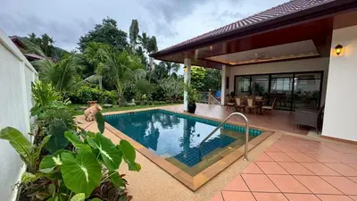 a house with a swimming pool in front of a house at Lai Thai Villa 5 in Rawai Beach