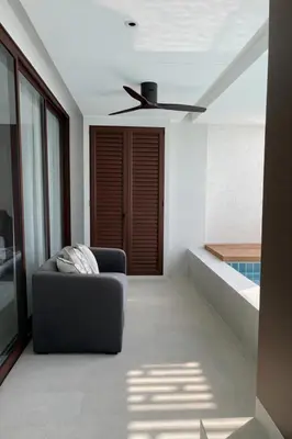 a living room with a couch and a ceiling fan at Потрясающие апартаменты на Банг Тао in Laguna Phuket