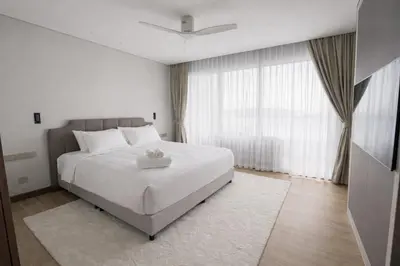 a bedroom with a white bed and a large window at Потрясающие апартаменты на Банг Тао in Laguna Phuket