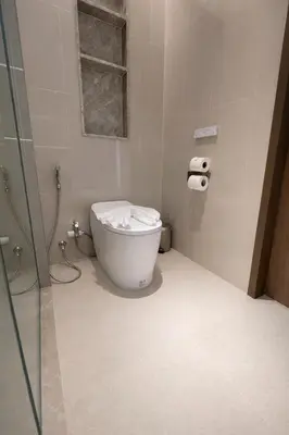 a bathroom with a toilet and a glass shower at Потрясающие апартаменты на Банг Тао in Laguna Phuket