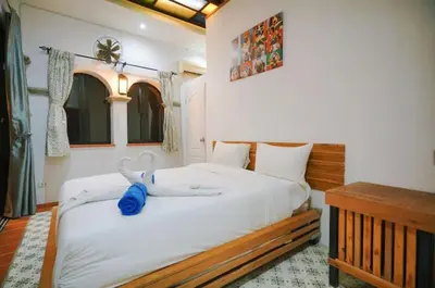 a bedroom with a bed with a stuffed animal on it at Beautiful 4 bedroom ocean view white house, steps from the beach Rawai Beach in Nai Harn Beach