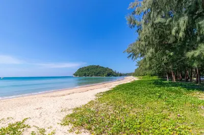 a beach with trees and the ocean on a sunny day at Laguna Cozy 3 bedroom town house 800m to beach in Laguna Phuket