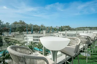 a group of chairs and a table on a balcony at New Boutique Studio, Near the Sea in Layan Beach