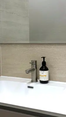 a bathroom sink with a bottle of soap and a faucet at The Regent new apartment in Ban Thalat Choeng Thale