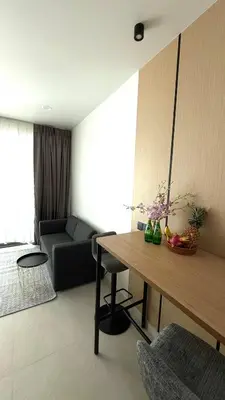 a living room with a table and a couch at The Regent new apartment in Ban Thalat Choeng Thale