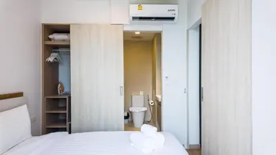 a bedroom with a bed with two white towels on it at Apartments in the center of Laguna in Laguna Phuket