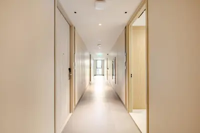 a corridor in a building with white walls and a long hallway at Apartments in the center of Laguna in Laguna Phuket