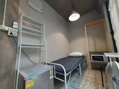 a small room with a bed and a shelf at FanRoomGroundFlNonehotshower in Ban Ket Ho