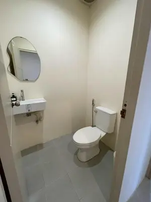 a bathroom with a white toilet and a mirror at Acacia Phuket in Nai Harn Beach