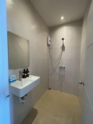 a bathroom with a sink and a shower with a mirror at Acacia Phuket in Nai Harn Beach