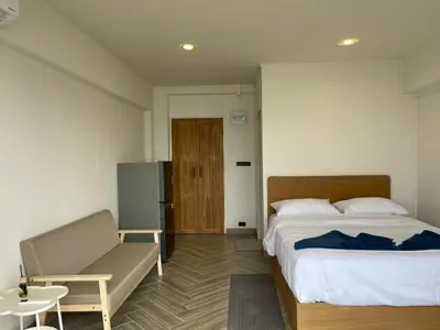 a bedroom with a bed and a chair and a door at Acacia Phuket in Nai Harn Beach