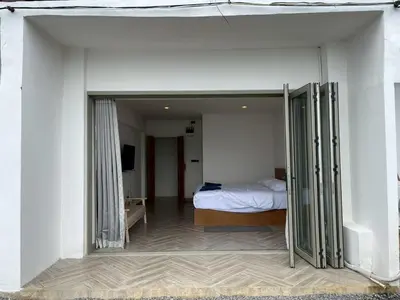 a bedroom with a bed in a white room at Acacia Phuket in Nai Harn Beach