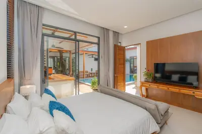 a bedroom with a large bed and a television at URMI VILLA, Brand New Luxury 6BR Pool, Bang Tao in Koh Lone