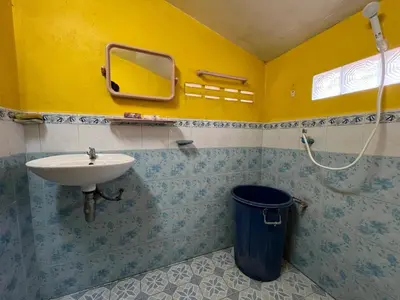 a bathroom with a sink and a mirror and a trash can at Ja Mia's Bungalow at Pasai Beach in Ko Yao Noi