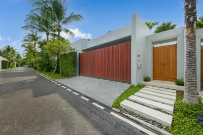a house with a red door and a street at Private 3BR Pool Villa Mana at Anchan Tropicana in Ban Phru Champa