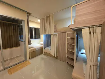 a small room with two beds and a large mirror at The Rock Poshtel Patong in Patong Beach