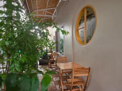 a room with a table and chairs and a mirror at The Rock Poshtel Patong in Patong Beach