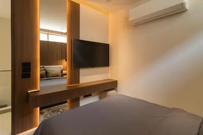 a bedroom with a bed and a tv and a mirror at Grand View Family Villa 5 min to Beach in Ban Thalat Choeng Thale