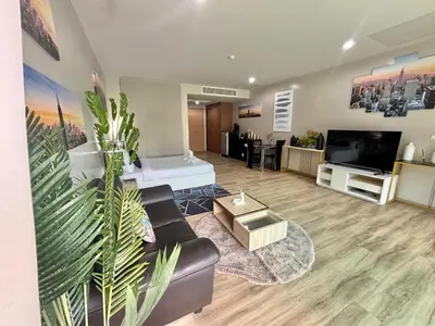 a living room with a couch and a flat screen tv at Karon Beach Forest View in Ban Karon