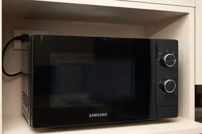 a black microwave oven sitting on top of a counter at Bellevue Lagoon by My Home Phuket in Laguna Phuket