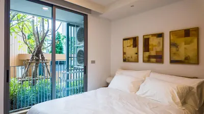 a bedroom with a bed and a large window at Apartment 2 bedrooms in SkyPark in Laguna Phuket
