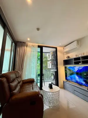 a living room with a couch and a large aquarium at Citygate condo at Kamala Beach in Kamala Beach