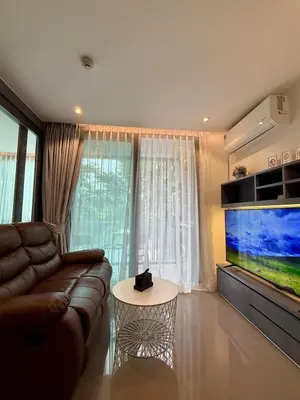 a living room with a couch and a large flat screen tv at Citygate condo at Kamala Beach in Kamala Beach