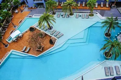 an overhead view of a large swimming pool with palm trees at Citygate condo at Kamala Beach in Kamala Beach