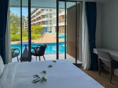 a bedroom with a bed and a view of a pool at Sunshine Layan Beach Resort 1 bedroom #84196 in Layan Beach