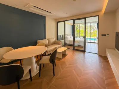 a room with two tables and a couch and a bed at Sunshine Layan Beach Resort 1 bedroom #84196 in Layan Beach