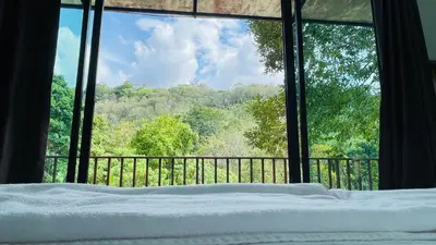 a bed in front of a window with a view at บ้านสกุลลี-House of Lee in Ban Huai Sai