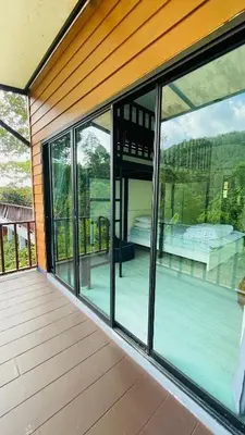 an empty house with glass windows and a patio at บ้านสกุลลี-House of Lee in Ban Huai Sai