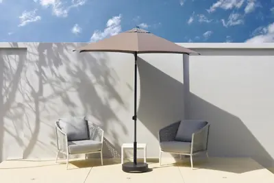 two chairs and an umbrella on a patio at Botanica Pru Jampa by Beringela in Phuket