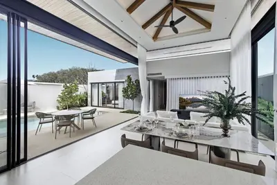an open living room with a table and chairs at Botanica Pru Jampa by Beringela in Phuket
