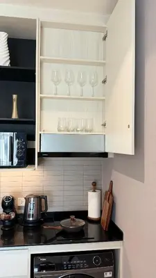 a kitchen with white cabinets and glasses on the counter at Cozy Apartment 1 km to Bangtao beach in Bang Tao Beach