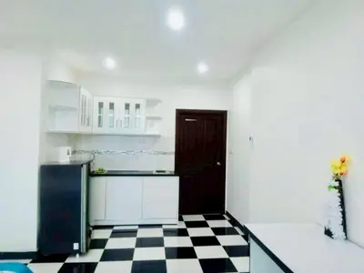 a kitchen with a black refrigerator and a checkered floor at TK Apartment By Wijitra in Ban Saiyuan (1)