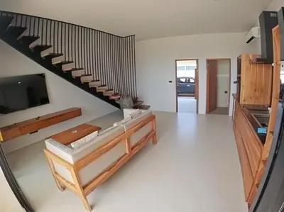 a living room with a staircase and a tv at Rawai 2 Bedrooms Private Pool Villa in Ban Saiyuan (1)