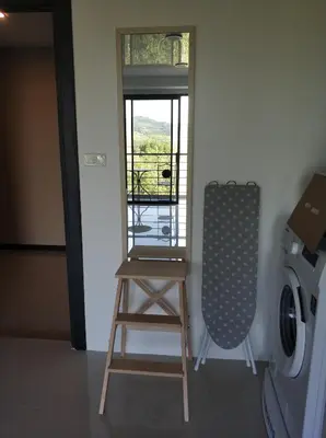 a laundry room with a stool and a washing machine at CC620 View of Green Hills in Ban Mai Salae