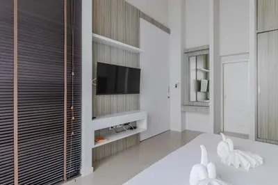a living room with a television and a white couch at V144 Luxury Private Pool Villa in Ban Saiyuan (1)