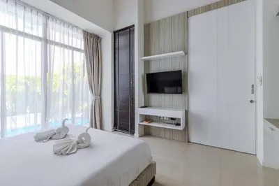 a bedroom with a bed with a tv and a large window at V144 Luxury Private Pool Villa in Ban Saiyuan (1)
