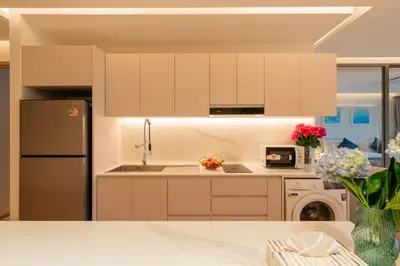 a kitchen with white cabinets and a refrigerator at Lakefront suite The Aqua at Boat avenue in Bang Tao Beach
