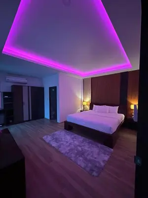 a bedroom with a bed with a pink lighting at Luxury 4BR Private Pool Villa Sunset Rooftop in Phuket Town