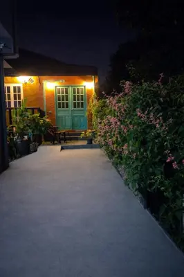 a house with a green door and flowers at night at Earth House HomeStay Bangjo in Ban Pak Lak