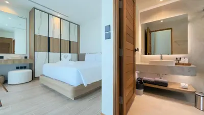 a bedroom with a bed and a bathroom with a sink at Phuvista Villas Naithon by Escape Villas - Brand New 3 BR Pool Villa - 500m from the beach in Phuket Town