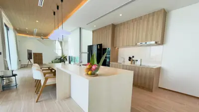 a kitchen with a white island in a room at Phuvista Villas Naithon by Escape Villas - Brand New 3 BR Pool Villa - 500m from the beach in Phuket Town