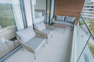 a balcony with chairs and a bed and a couch at Coastal 1 bd apartment - Moments from the sea in Layan Beach