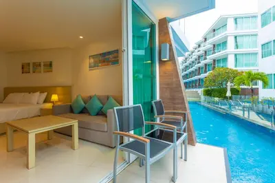 a hotel room with a bed and a pool at C109 Beachfront Seaside Escape Pool Access in Ban Saiyuan (1)