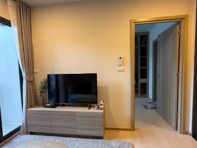 a living room with a flat screen tv on a dresser at Phuket, Best location, full furnished 1bedroom in Ban Rangeng